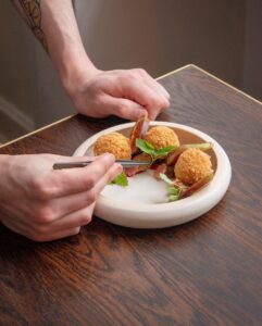 Chef preparing a gourmet starter at No.4 Clifton Village, a premium fine dining restaurant in Bristol’s Clifton Village, known for its beautifully crafted dishes and intimate dining atmosphere.