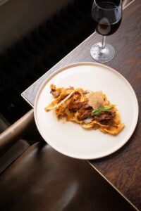 A beautifully plated dish of fresh tagliatelle with slow-cooked ragu, served at No.4 Clifton Village in Bristol. This rich, indulgent pasta dish is perfectly complemented by a glass of red wine, capturing the essence of fine dining in Clifton Village. With Postcode Perks, locals can enjoy exclusive dining discounts at No.4 Clifton Village, one of the best restaurants in Bristol for authentic, high-quality cuisine. Whether you're looking for a romantic dinner spot in Clifton or the best small plates in Bristol, this venue offers an unforgettable culinary experience.